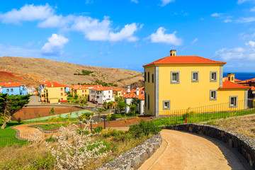 Fototapeta na wymiar Walking alley in park with tropical plants and colourful houses near Canical town, Madeira island, Portugal
