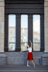 Outdoor portrait of a cute little girl of 7 years old, walking to dance school and dancing in the street, wearing purple ballet dress