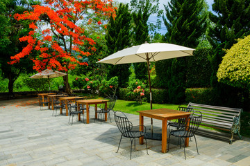 Obraz premium Drewniany stół na krzesłach w ogrodzie