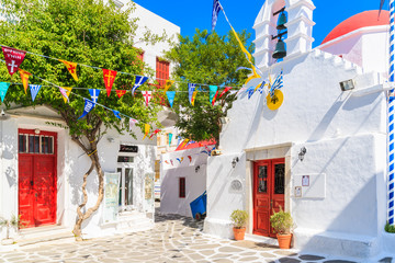 MYKONOS ISLAND, GREECE - MAY 17, 2016: Small square with church building on whitewashed street in beautiful Mykonos town, Cyclades islands, Greece. © pkazmierczak