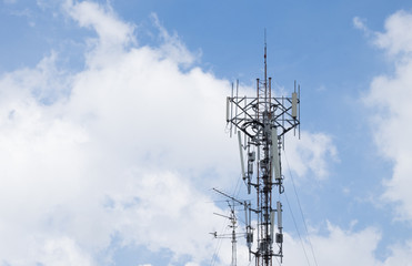 Communication tower transmission signal and antenna with sky background.