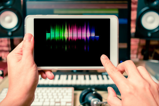 music background, fingers touching computer tablet in sound studio 