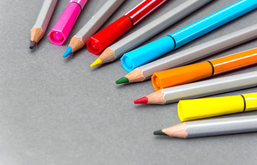 Colored felt tip pen and colored  pencils on the gray background.