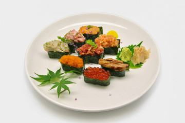 Mixed nigiri sushi (Uni (sea urchin), Ikura (salmon roe), Tobiko (flying fish roe), Otoro,Shutoro, salmon) in white plat on white background
