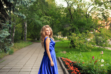 Beautiful girl is walking in a blue dress