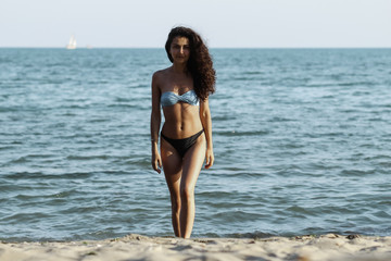 Obraz premium Hight fashion colors,Glamour Portrait of pretty beautiful fashion woman in bikini posing in summer near the sea and blue sky in sunshine,tropic island girl on vacation