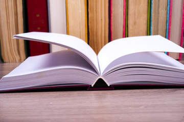 Open book, hardback books on bright colorful background.