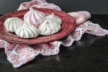 Meringue in a plate on a dark background