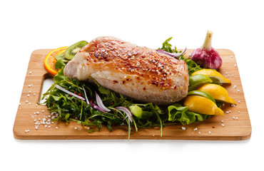 Roast ham with vegetables on wooden desk