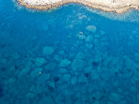 Vista aerea di scogli nel mare. Panoramica del fondo marino visto dall’alto, acqua trasparente