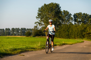 Fototapeta premium Woman riding bicycle in countryside