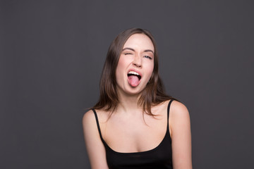 Fototapeta premium Beautiful modern girl shows tongue