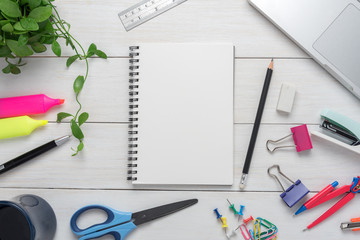 Notepad and stationery and office supplies on white table.