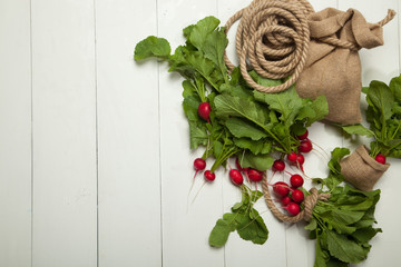 Fresh radishes on a white wooden background