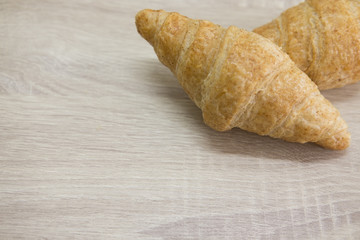 CROISSANT
Two brown croissant on the wood table.