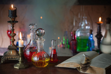 Obraz na płótnie Canvas Magic potion, ancient books and candles on dark background
