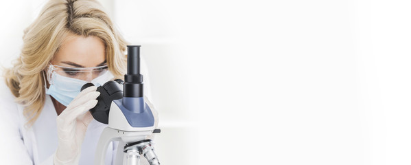 Female doctor looking through a microscope