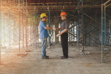 Engineer discussing with foreman about project in building construction site