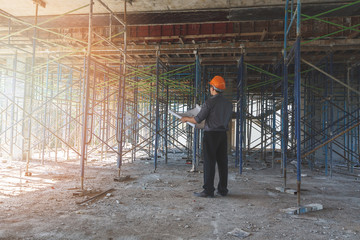 Engineer with blueprint in building construction site