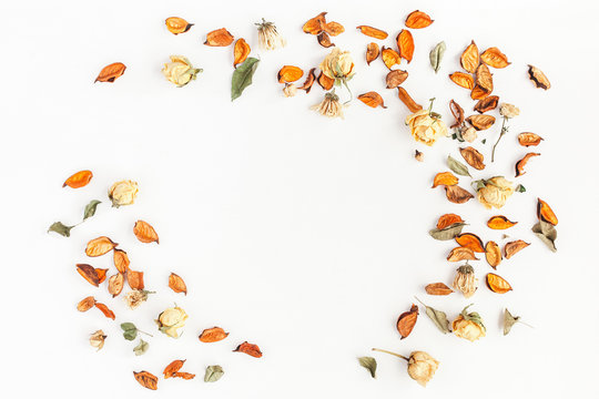 Autumn composition. Frame made of autumn dried flowers and leaves on white background. Flat lay, top view, copy space
