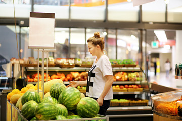 Middle-age woman buying watermelon at the market