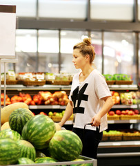 Middle-age woman buying watermelon at the market