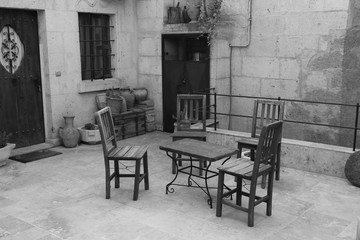 A court yard with a table and chairs in black and white in turkey, 2017