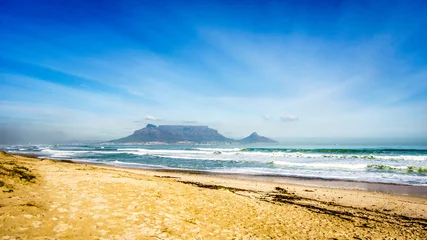 Photo sur Plexiglas Montagne de la Table Early morning view of Cape Town and Table Mountain with Lion's Head and Signal Hill on the right and Devil's Peak on the left. Viewed from Bloubergstrand just north of the city