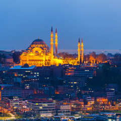 Obraz premium View of Istanbul from the sea at dusk. Mosque in the old town with night illumination of facades on the background of urban development. Travel Turkey.