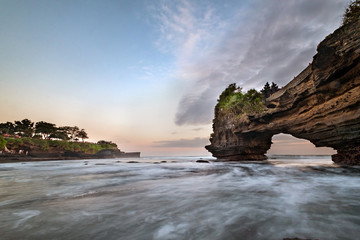 Sunset near famous tourist landmark of Bali island - Tanah Lot & Batu Bolong temple. Long exposure effect, Bali Indonesia. Tropical nature landscape of Indonesia, Bali.