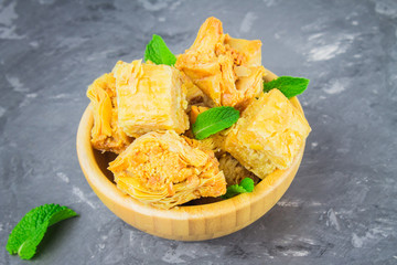 baklava turkish traditional delight on a dark wood background. toning