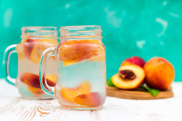 Homemade iced lemonade with ripe peaches. Fresh peach ice tea in a mason jar.
