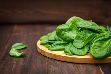 Fresh juicy spinach leaves on a wooden brown table. Natural products, greens, healthy food, vitamins.