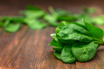 Fresh juicy spinach leaves on a wooden brown table. Natural products, greens, healthy food, vitamins.