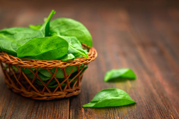 Fresh juicy spinach leaves on a wooden brown table. Natural products, greens, healthy food,...