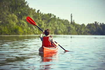 A canoe trip along the river along the forest in summer.