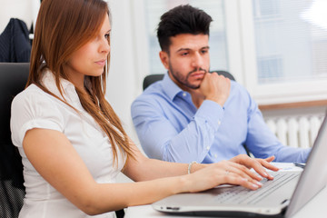 Obraz premium Business people using a laptop computer in their office