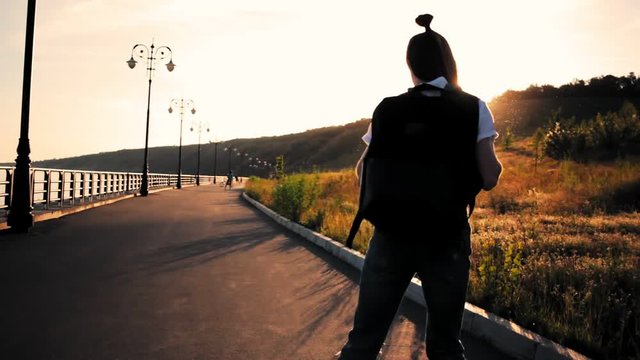 Young funky girl riding roller skates during sunset