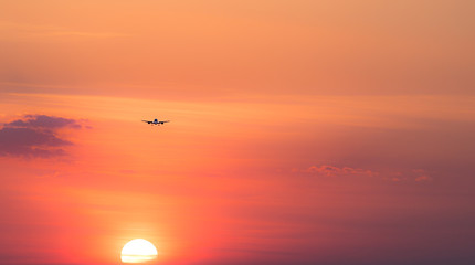 Lądujący samolot o zachodzie słońca