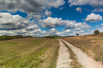 Dirt road in the Czech Republic. Clouds before the thunderstorm. Summer day in the countryside.