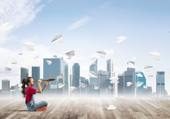 Obraz premium Concept of careless happy childhood with girl looking in spyglass