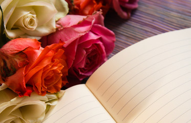 Colorful roses and an open notebook