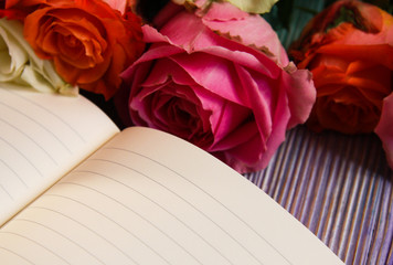 Colorful roses and an open notebook