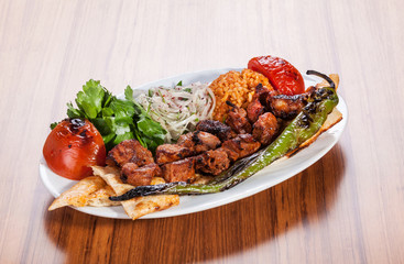 Barbecue skewers with meat served vegetables on wooden table