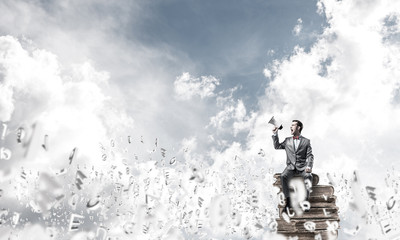 Businessman announcing something in loudspeaker and symbols fly 