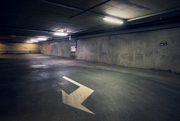 Empty dark abstract concrete room interior with white arrow. Architectural background.