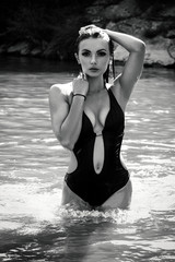 Seductive sexy girl or woman in erotic underwear and stands in the middle of a pond