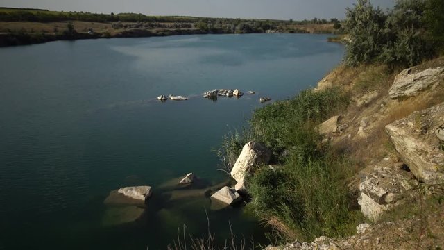 Flooded granite quarry. Freshwater lake. Beautiful nature around