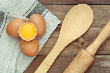 Top view on fresh eggs and rustic wooden kitchen utensil