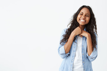 Portrait of pretty woman with dark clean skin and beautiful smile laughing out loud at funny joke...